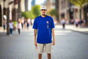NWD Official Blue t-shirt front with graphics on the left side on person in a downtown street scene